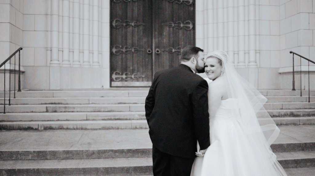 bride and groom kissing in front of a church