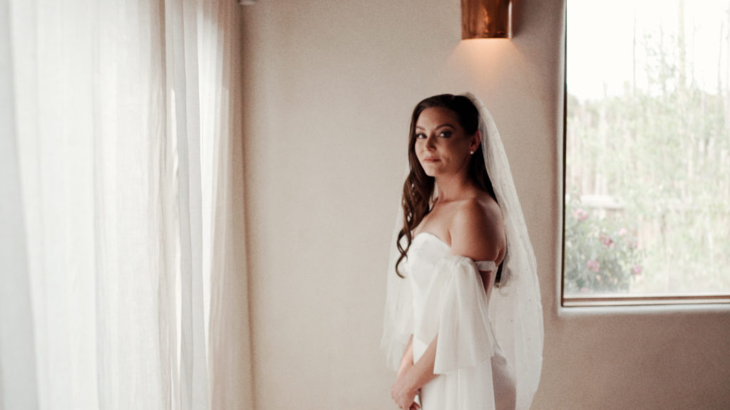 bride standing in a white room looking at the camera