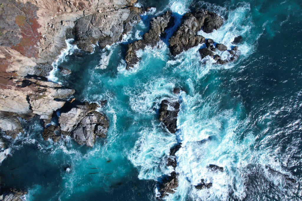 aerial image of a rocky, blue coastline