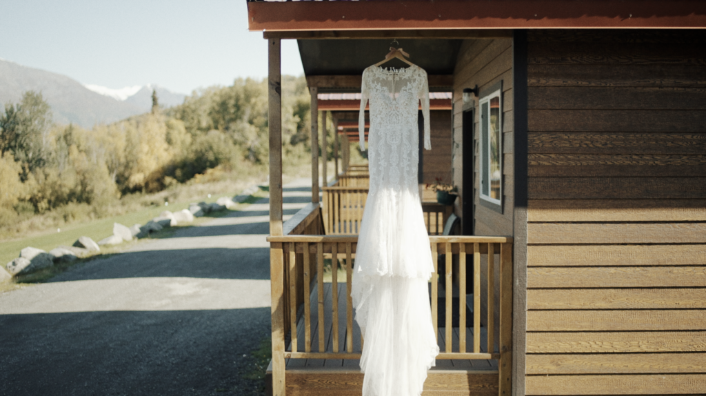 lace wedding dress hanging from the roof of a cabin